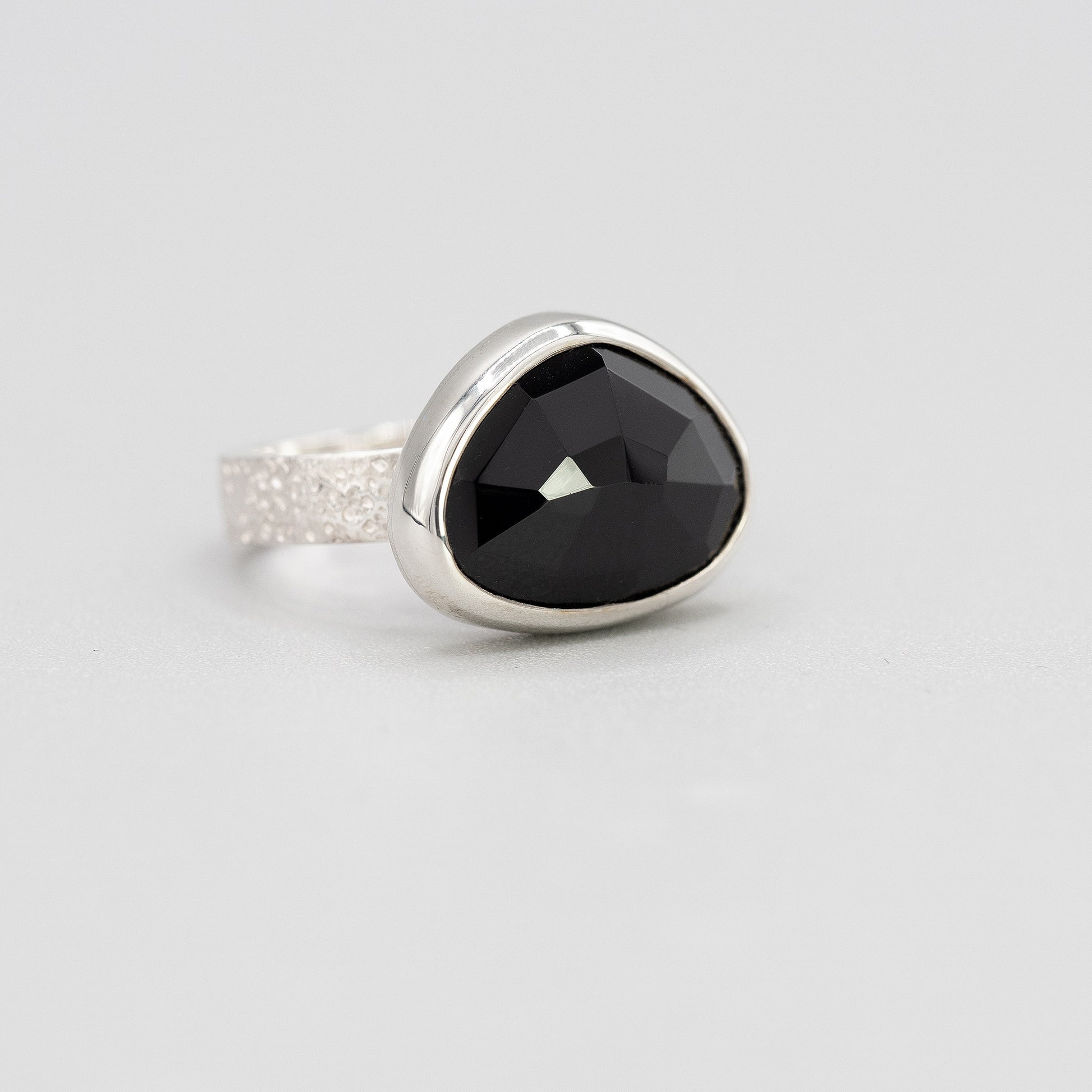 Silver ring with black spinel gemstone in a bezel setting 
