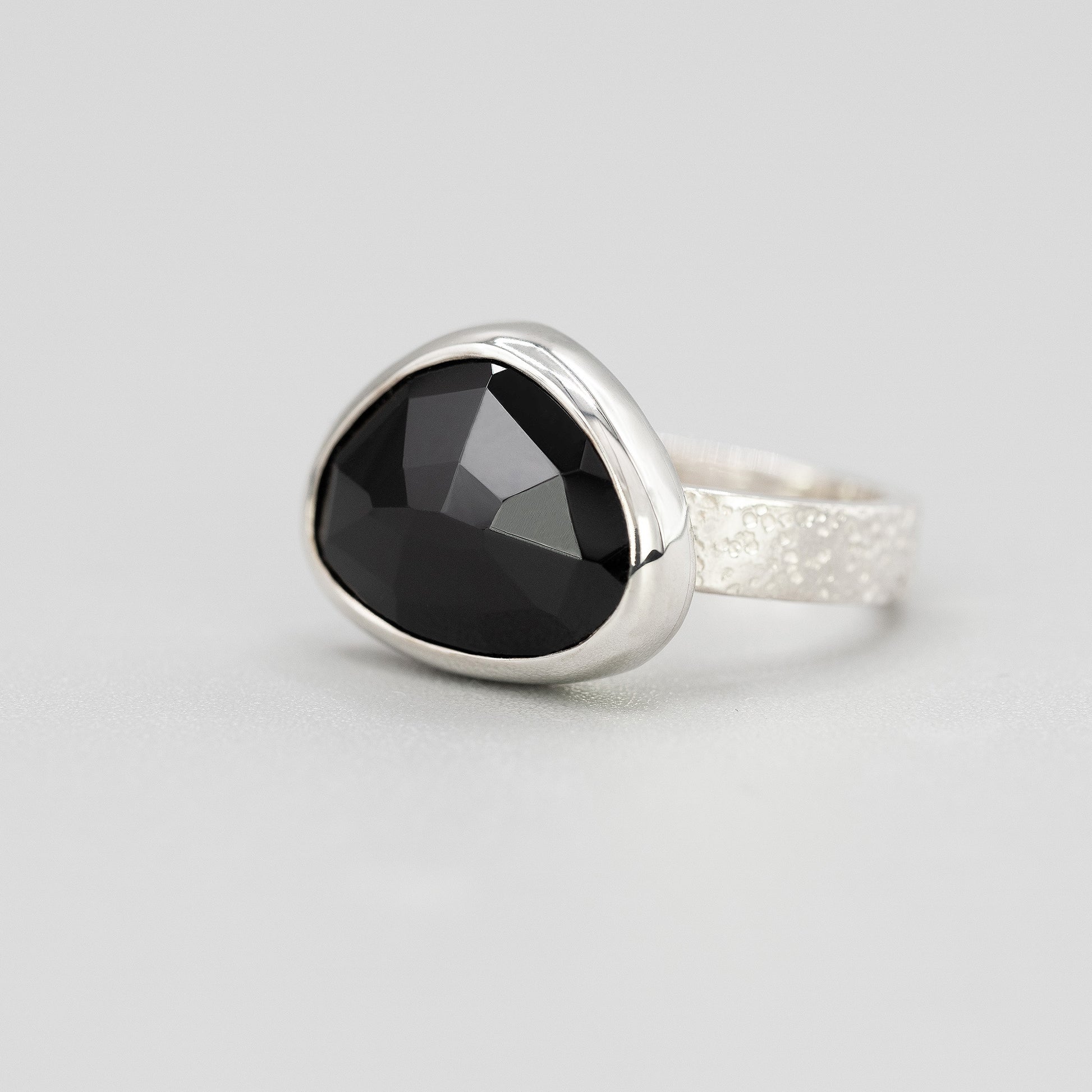 Silver ring with black spinel gemstone in a bezel setting 